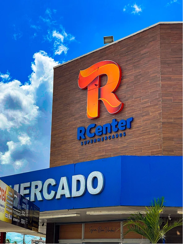 Fachada da loja R Center Santa Rosa com o logo da marca sob céu azul